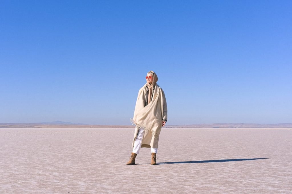 A Woman Wearing a Hoodie anda Scarf in the Desert